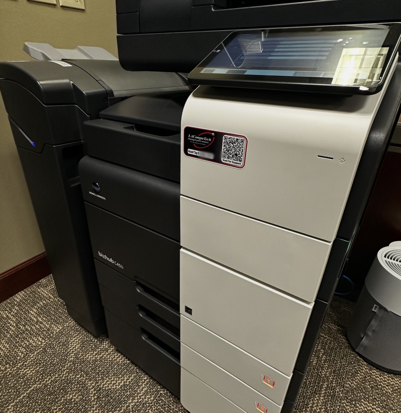 A managed Konica Minolta multifunction printer on the office floor