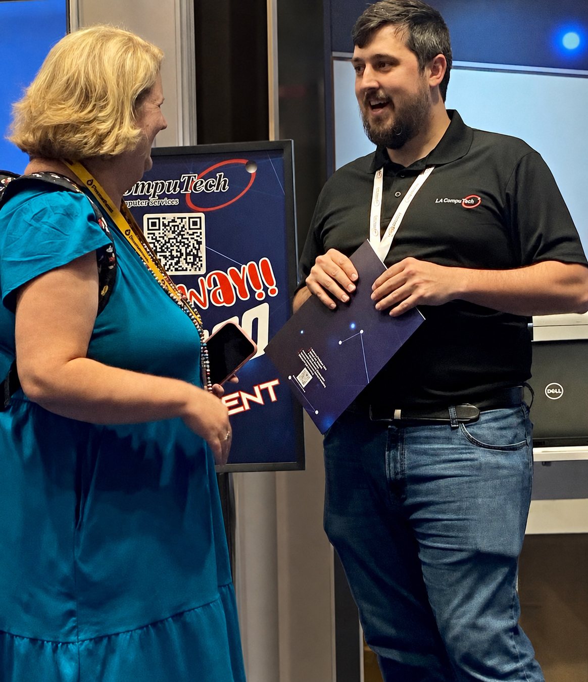 An LAComputech team member talking with a customer at an industry event